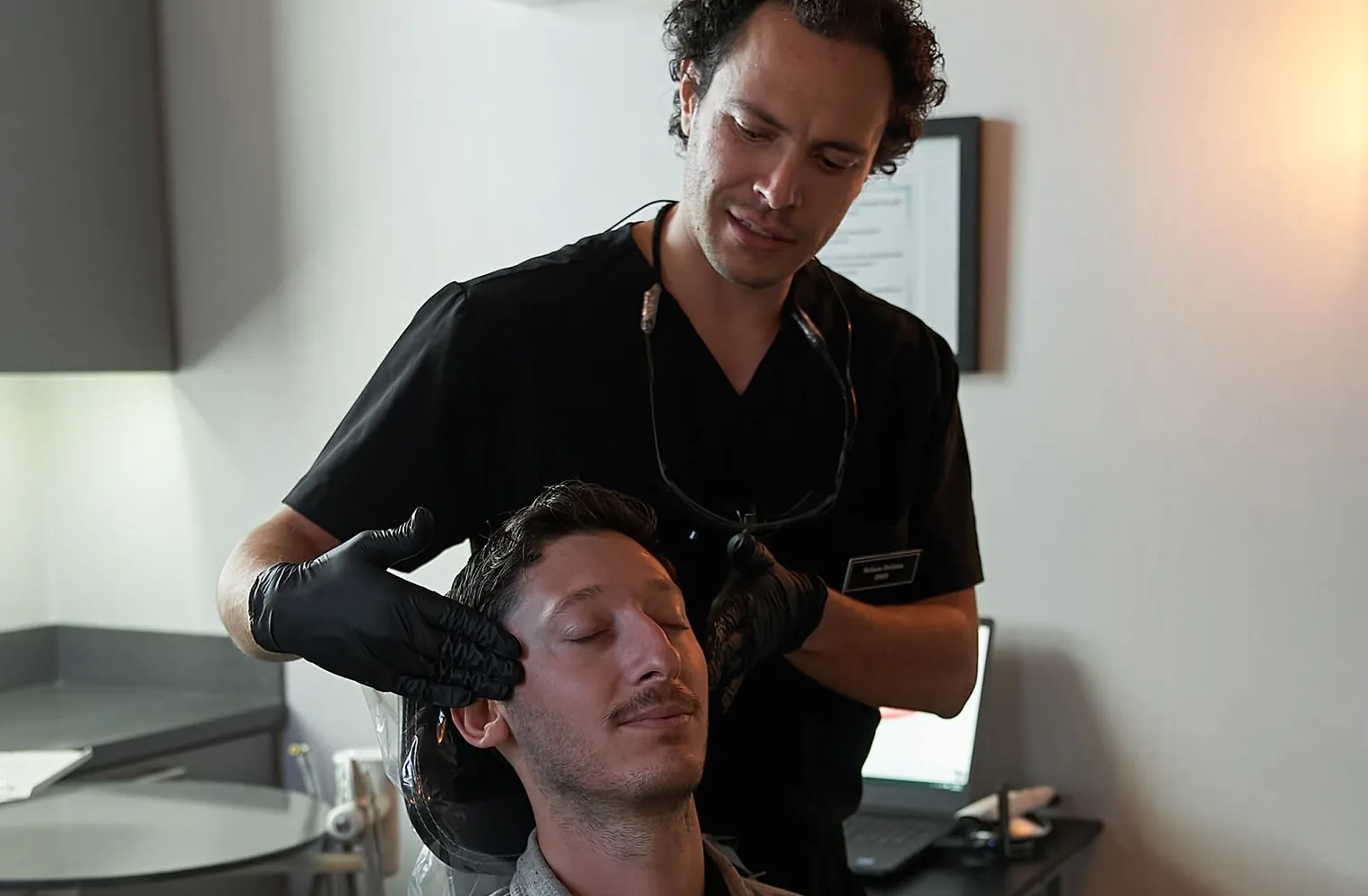 Dr. Nelson DeLima examining a patient’s jaw at Red Bank Smiles in Red Bank, NJ